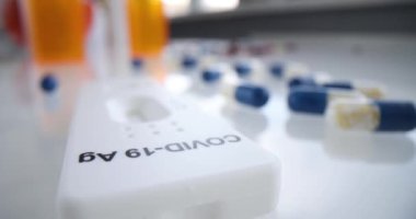 Bu resimde COVID19 test kiti farklı ilaç ve ilaç çeşitlerinin yanına yerleştirilmiş.