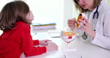 Bir doktor muayenesinde, bir çocuk tıbbi bir modelle etkileşim yoluyla hayati sağlık bilgilerini öğrenir.