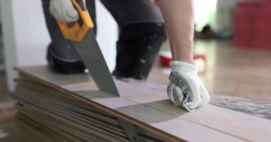 Bir birey geleneksel bir el testeresi kullanıyor. Bir DIY yenileme projesi için ahşap tahtaları ustalıkla kesiyor.