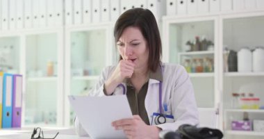 Laboratuvar önlüklü kadın doktor endişelerini dile getiriyor. Kadın doktor, tedavi seçeneklerini göz önünde bulundurarak hastanın geçmişini analiz ediyor.
