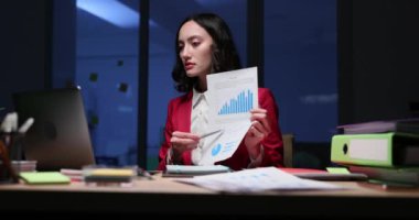 Genç kadın, video toplantısı sırasında detaylı grafiği gösteriyor. Odaklanmış iş kadını çizelgede gösterilen sonuçları açıklıyor. Yavaş çekim