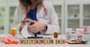 Bir sağlık uzmanı bugün bir eczane ortamında B6 vitamini takviyelerini iyice analiz ediyor.