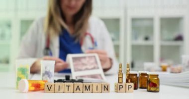 Bir sağlık görevlisi çeşitli vitamin ve takviyeleri titizlikle inceler, özellikle de PP vitaminine odaklanır.