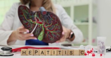 Bir tıp uzmanı Hepatit C farkındalığının ve eğitimin önemini vurgulayan bir karaciğer modelini inceler.