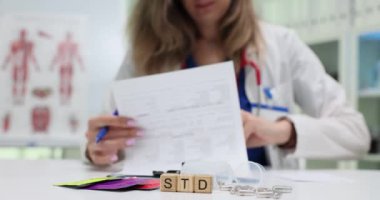 Bir klinikte, kendini adamış bir sağlık görevlisi tıbbi belgeleri ve STD test sonuçlarını inceliyor.