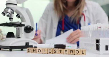 Kolesterol testlerini mikroskop ile gösteren bir laboratuvar sahnesi.