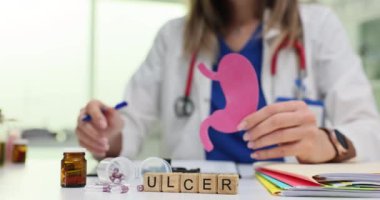 Doktor mide ülseri olan bir hastayı muayene eder, önemli sağlık hizmetleri ve tıbbi tavsiyelere dikkat çeker.
