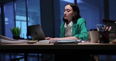 Mikrofonlu bir kadın müşteri sorularını dinler. Esmer ofis çalışanı müşteriye yanıt veriyor ve ilgili ayrıntıları çevrimiçi sisteme giriyor