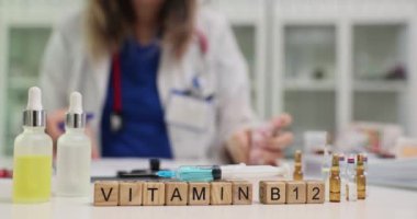 Hastanedeki doktorlara karşı ilaç ampullerinin yakınındaki küplerden alınan B12 vitamini. Üniformalı kadın doktor hasta için reçete yazan haplar tutuyor.