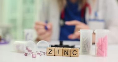 Masa başındaki Çinko 'dan doktorlara karşı ilaveler. Steteskoplu kadın sıhhiye hastanedeki hastaya mikro element reçetesi yazıyor.