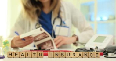 Klinikte bilgisayarla taranmış görüntüleri olan doktorlara karşı sağlık sigortası ifadesi. Steteskoplu kadın doktor, iş yerindeki ultrason muayene sonuçlarını inceliyor.