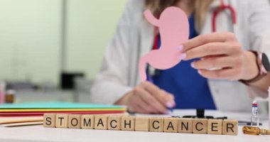Küpler üzerinde kelime kanseri ve masada kağıt parçalarını tutan doktor. Kadın tıp uzmanı hastanedeki tehlikeli hastalıklar hakkında uyardı
