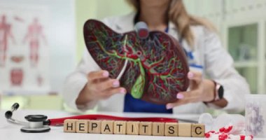 Hepatit C ve tıp uzmanı karaciğer modelini hastanede tutuyor. Klinikte teşhis araçları ve tedavi protokolleri olan bir doktor.