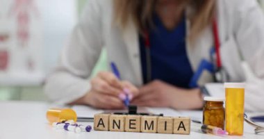 Ahşap bloklardan oluşan Anemi ve masadaki tıbbi profesyonel tedavi. Kadın doktorlar klinikte hasta bakımı stratejisi hazırlıyorlar.