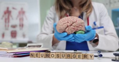 Sinir cerrahisi ve profesyonel kadın cerrah klinikte beyin anatomisi modeli gösteriyor. Kadın doktor nörolojik hastalıklar hakkında hastalara danışıyor