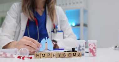 Amfizem ve sağlık görevlisinin elinde kağıt ciğer, kesilmiş maket var. Kadın doktor, hastanedeki solunum hastalıkları bilincini temsil ediyor