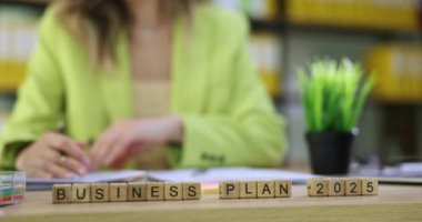 İş Dünyası Planı 2025, iş kadınlarına karşı küplerin ofiste notlar alması üzerine. Yeşil ceketli kadın, ortak için pul hazırlama anlaşması yaptı