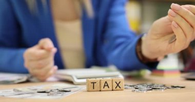 İş yerine bozuk para atan kadınlara karşı ahşap küplerden alınan vergiler. Mavi ceketli kadın işçi çeşitli vergiler için para sayıyor.