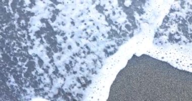 Yumuşak beyaz deniz köpüğü yaz günü korku kelimesiyle karanlık kumun üzerinde hafifçe süzülür. İnsanların duygularının hayatı etkilediği yanıltıcı doğası kavramı