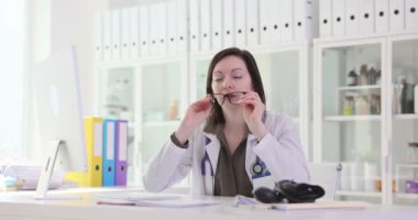 Yorgun kadın doktor klinikteki işyerinde gözlük masajını kaldırıyor. Kadın sıhhiye vardiyası sonrası yorgunluk yaşıyor