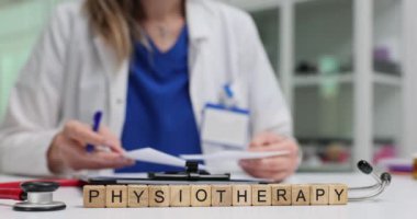 Tahta blokların fizyoterapisi ve doktorların masa başı işleri. Kadın terapist hastanede tedavi programı hazırlıyor