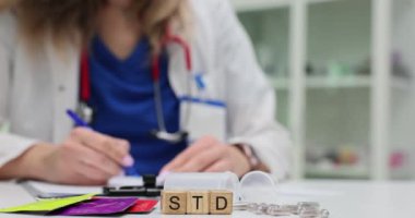 Tahta küplere ve prezervatiflere uygulanan STD kısaltması hastanede panoya yazı yazan doktorlara karşı. Cinsel yolla bulaşan hastalık bilinci