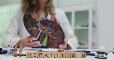 Hepatit B 'ye insan karaciğeri anatomik modelini tutan sıhhiyeye karşı şişelerin yakınındaki bloklarda mesaj at. Doktor bulaşıcı organ hastalığı hakkında bilgi veriyor.