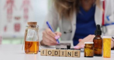 Doktorun klinikte not yazmasına karşı ilaç içeren ahşap küplerden oluşan bir iyot. Sağlık uzmanları refah için ilave reçete yazar.