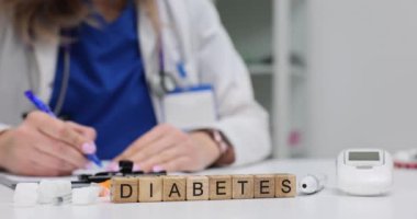 Doktor muayenehanesinde glukometre insülin ve şeker küplü tahta blokların diyabeti. Modern hastanede kronik hastalık farkındalığı