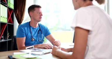 Parlak ve modern sağlık hizmetleri ortamında, bir doktor bir hastaya sağlığı hakkında danışmanlık yapmaktadır.