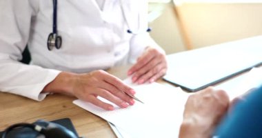 Bir doktor, konsültasyon sırasında hastayla etkin bir şekilde iletişim kurar, sağlık hizmetleri ve profesyonelliğin altını çizer