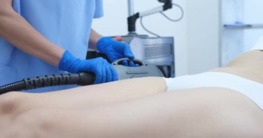 Estetik bir profesyonel, bir müşterinin vücudunda gelişmiş teknolojiyi kullanarak özel bir tedavi uyguluyor.