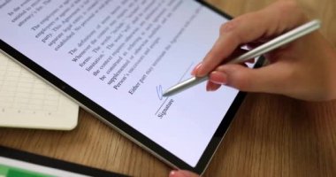 Bir kişi, modern üretkenlik araçları ve tekniklerini gösteren yüksek teknolojili bir tablete not almak için stil kullanır.