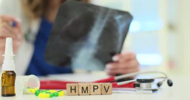 Bir sağlık çalışanı, klinik bir ortamda analiz için çeşitli tıbbi araçlar içeren bir röntgen görüntüsünü inceliyor.