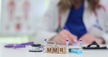 Bir sağlık uzmanı şırınga ve çeşitli temel tıbbi araçlar kullanarak MMR aşısını aktif olarak hazırlıyor.