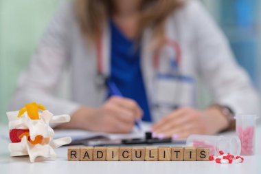 Bir doktor, omurilik modelini incelerken ve klinik çevredeki notları incelerken radyöz iltihabı iyice inceler.