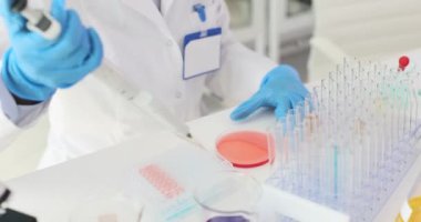 Laboratuvar teknisyeni sıvı dağıtmak için gelişmiş ekipman kullanır. Deneyimli bir laboratuvar çalışanı detaylı analiz için örnekler hazırlar. Yavaş çekim