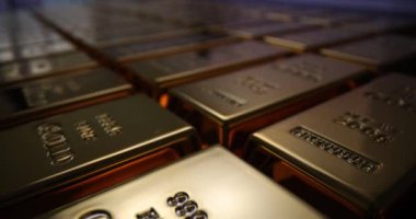 Parlayan altın külçeleri düzgün ve mükemmel sıralarda dizilmiş. Yansıtıcı yüzeyleri olan altın çubuklar güvenli kasada kusursuz sıralarda yatıyor.