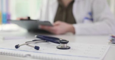 Çocuk doktoru, panoya iliştirilmiş önemli bir belgeyi okuyor. Profesyonel doktor randevusundaki hastanın tıbbi geçmişini inceliyor. Yavaş çekim