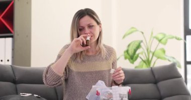 Hasta kadın burun tıkanıklığını gidermek için burun spreyi kullanıyor. Kadın burun tıkanıklığını azaltmak ve evde daha kolay nefes almak için sprey kullanıyor. Yavaş çekim