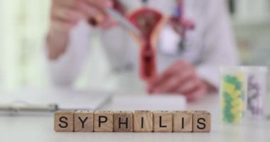 Doktorun rahim modeli göstermesine karşı küp kelime frengisi. Jinekolog tehlikeli hastalıklara açıklama getiren kalemle işaret ediyor.