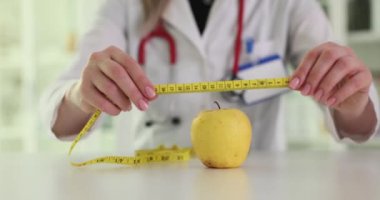 Doktor elmayı, iş yerinde şerit kontrol parametreleriyle sarar. Kadın sıhhiyeci, ağırlığı kontrol etme özelliklerini şakayla anlatıyor