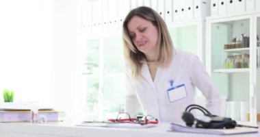 Kadın doktor iş yerinde steteskop takıyor. Üniformalı kadın doktor randevularına hazırlanıyor ve hastanede not alıyor.