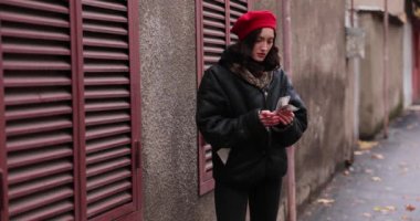 Endişeli genç kadın, sonbahar günü şehir merkezindeki kapalı kırmızı panjurların yanındaki banknotları sayıyor. Endişeli bayan şehirde mali güvensizlikle uğraşıyor