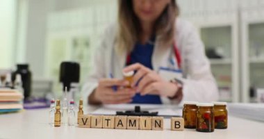 Bloklar üzerine B vitamini ve iş yerindeki kadın doktorların ilaç şişelerine mesaj at. Terapist, modern hastanede yavaş çekimde ilave ilaçlar için reçete yazıyor.