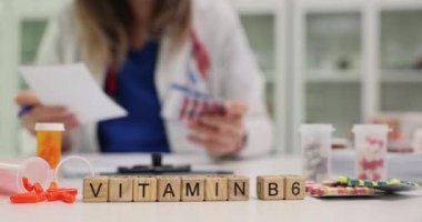 Kadın eczacı işyerindeki bloklu ve kapsüllü vitamin B6 'ya mesaj at. Hastanede yavaş çekimde iyileşme ve refah için ilaveler hazırlanıyor.