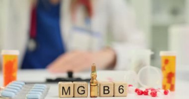 Magnezyumun kısaltması MG ve profesyonel tıp masasında B6 vitamini. Doktor tedavi planını hastanede ilaçlarla belgeleyecek.