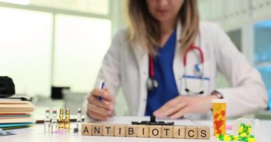 Antibiyotiği ve ilaçları kadın tıp masasına gönder. Doktor klinik ofisinde reçeteli muayeneyi inceliyor. Yavaş çekim ayarlanıyor.