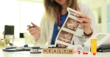 Tahta küplerin sağlığı ve kadın doktorun klinikteki ultrason görüntülerini incelemesi. Hastanın sağlığına ve doğru teşhislere adanmışlık