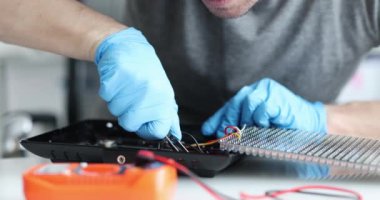 Eldivenli bir teknisyen, elektronik aletleri etkileyici bir hassasiyetle tamir ediyor.